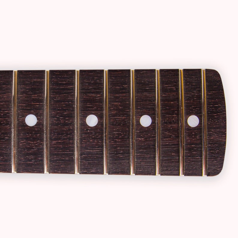 May include: A dark brown guitar fretboard with four white dot inlays.