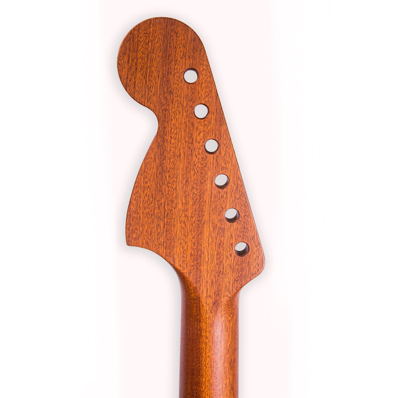 May include: A close-up of a natural wood guitar neck with a rounded headstock and six tuning pegs.