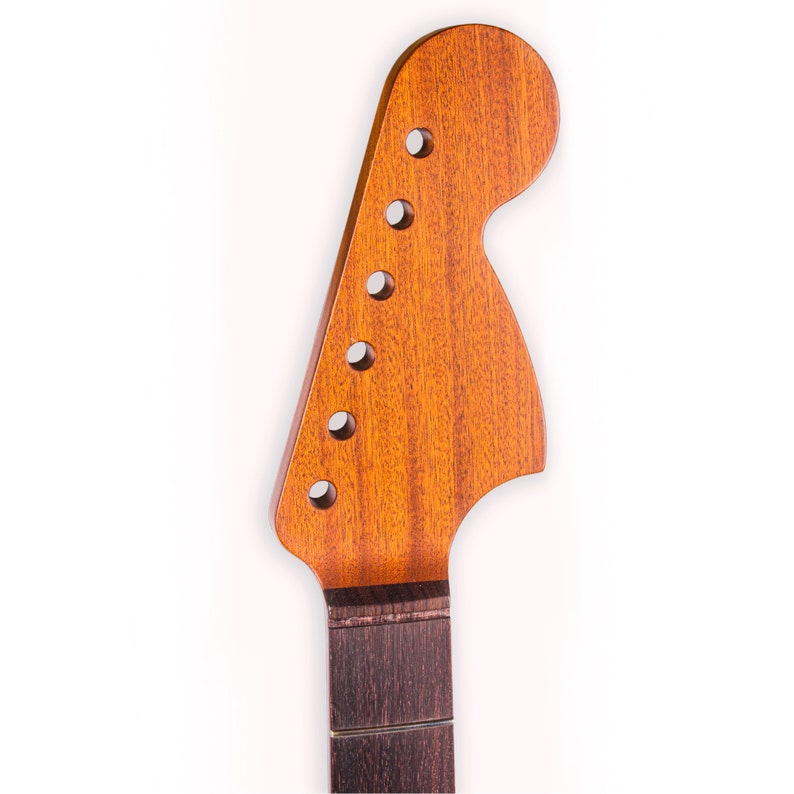 May include: A close-up of a guitar neck with a natural wood finish. The headstock is shaped like a teardrop and has six tuning pegs. The neck is made of rosewood and has a dark brown color.
