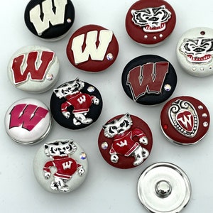 May include: A collection of round snap buttons featuring the University of Wisconsin Badgers logo and mascot. The buttons have a variety of designs, including the letter "W" and the badger mascot in red, white, and black.
