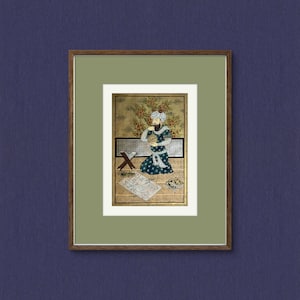 Peut inclure: Une peinture miniature encadrée représentant un homme portant un turban et une robe, assis sur un tapis, tenant un livre. Il est entouré d'un fond doré avec des détails complexes. La peinture est placée sur un passe-partout vert et un cadre brun.