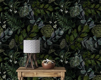 May include: A dark green and black wallpaper with a botanical pattern featuring leaves and seed pods. A wooden table with a lamp and a bowl with a starfish on top is in the foreground.