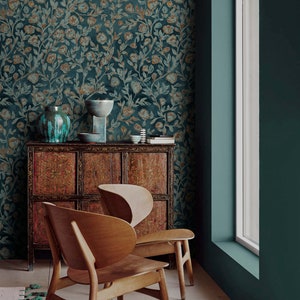 May include: Two wooden chairs with a curved back and a dark wood cabinet with intricate carvings. The cabinet is against a teal wall with a floral wallpaper featuring a teal and gold pattern.