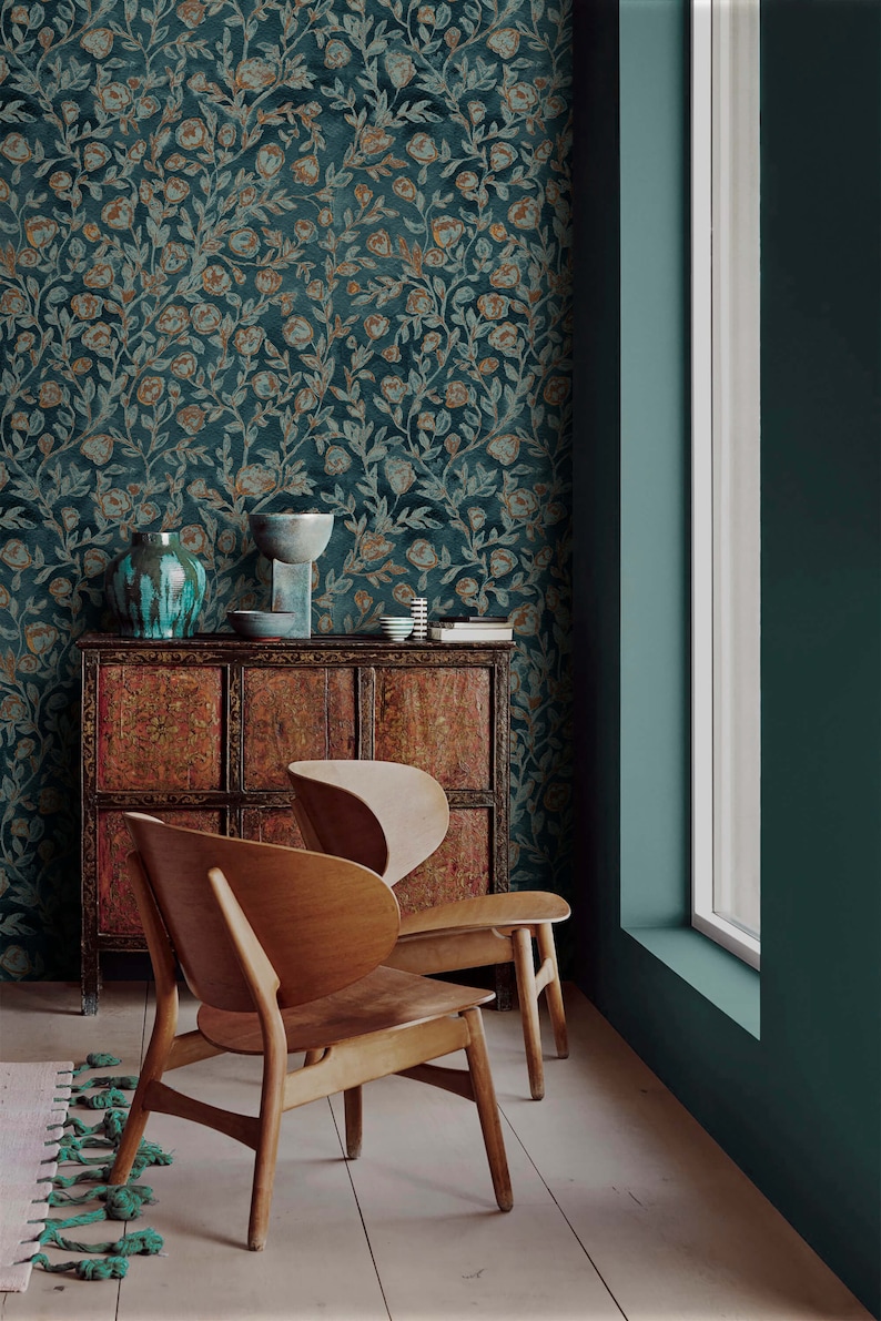 May include: Two wooden chairs with a curved back and a dark wood cabinet with intricate carvings. The cabinet is against a teal wall with a floral wallpaper featuring a teal and gold pattern.