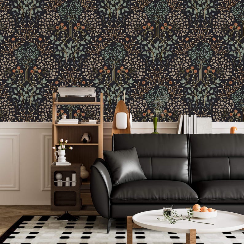 May include: A black leather sofa with a white coffee table in front of it. The wall behind the sofa is covered in dark wallpaper with a floral pattern. There is a wooden shelf unit to the left of the sofa.