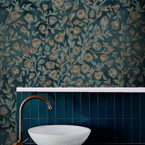 May include: A white porcelain sink with a brass tap, set against a teal tiled wall with a floral wallpaper backdrop. The wallpaper features a repeating pattern of brown and blue flowers and leaves.