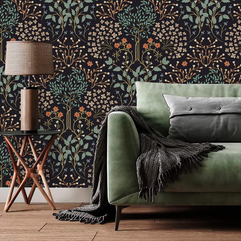 May include: A green velvet sofa with a black throw blanket and a gray pillow sits in front of a black wallpaper with a repeating pattern of stylized trees and flowers.