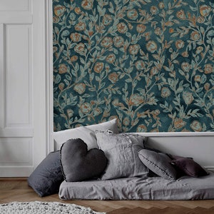May include: A grey daybed with a variety of grey throw pillows. The daybed is in front of a wall with a teal blue wallpaper featuring a floral pattern with gold accents.