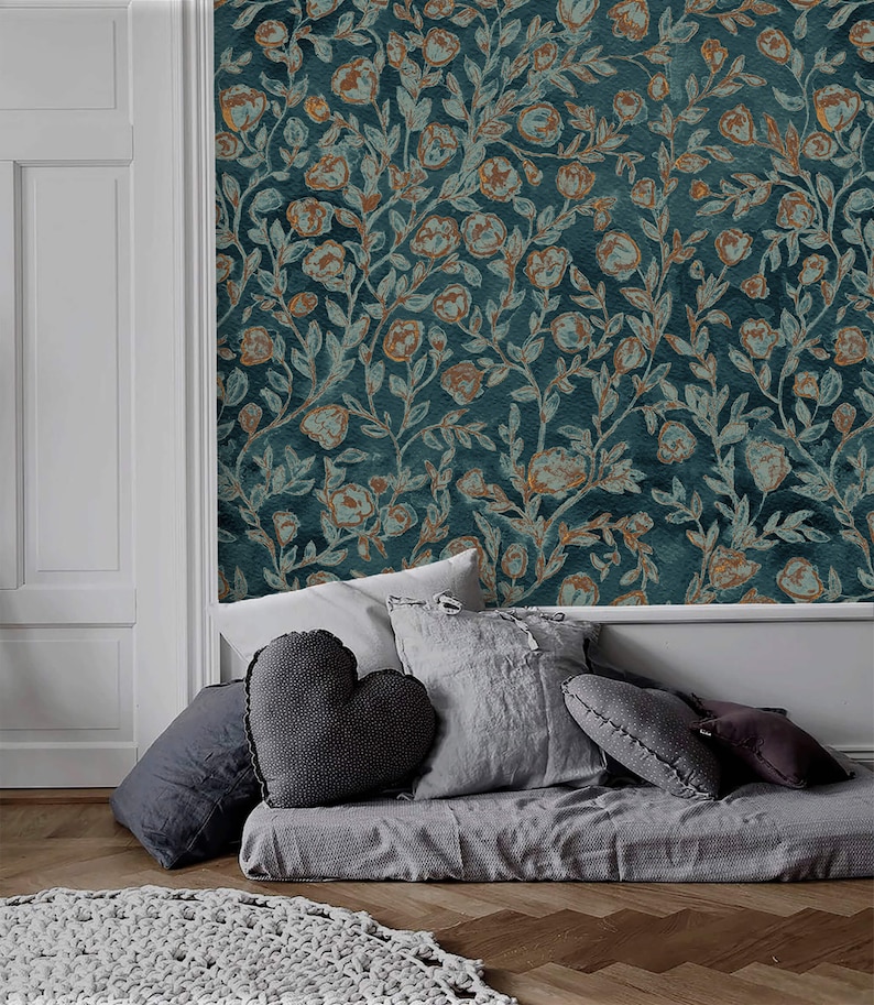 May include: A grey daybed with a variety of grey throw pillows. The daybed is in front of a wall with a teal blue wallpaper featuring a floral pattern with gold accents.