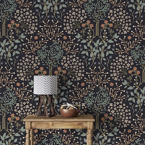 May include: A dark blue wallpaper with a repeating pattern of stylized trees and flowers in shades of green, orange, and white. A table with a lamp and a bowl sits in front of the wallpaper.