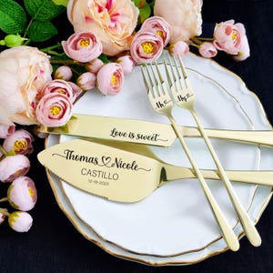 Personalized 4-piece champagne gold wedding cake cutting set. High-polish stainless steel server engraved with Thomas and Nicole Castillo 12-18-2025. Knife features 'Love is sweet' script. Shown on a gold-rimmed plate with romantic pink roses.