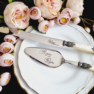 May include: A silver cake knife and server set with ornate handles. The knife has the text "Wright April 22, 2023" engraved on the blade. The server has the text "Regina and Dylan" engraved on the blade.