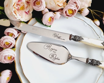 May include: A silver cake knife and server set with ornate handles. The knife has the text "Wright April 22, 2023" engraved on the blade. The server has the text "Regina and Dylan" engraved on the blade.