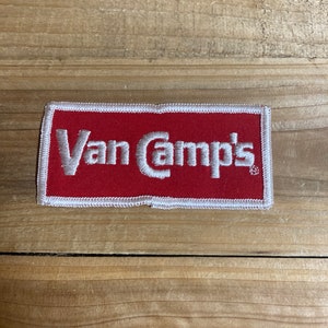 May include: A red embroidered patch with white stitching. The patch says "Van Camp's" in white lettering.
