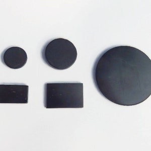 Könnte beinhalten: Vier schwarze runde und rechteckige Magnete in verschiedenen Größen.