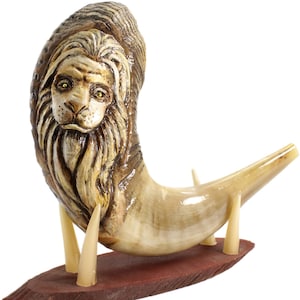 May include: A carved wooden shofar with a lion's face on the top, mounted on a wooden base with three prongs.