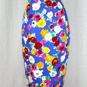 May include: A blue pencil skirt with a floral print featuring pink, red, yellow, and white roses.