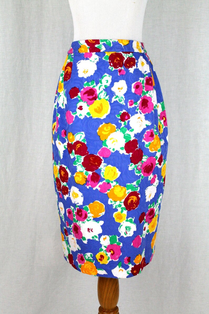 May include: A blue pencil skirt with a floral print featuring pink, red, yellow, and white roses.