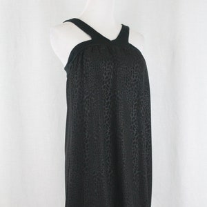 May include: A black sleeveless dress with a halter neckline and a snakeskin print. The dress has a gathered detail at the neckline and a fitted silhouette.