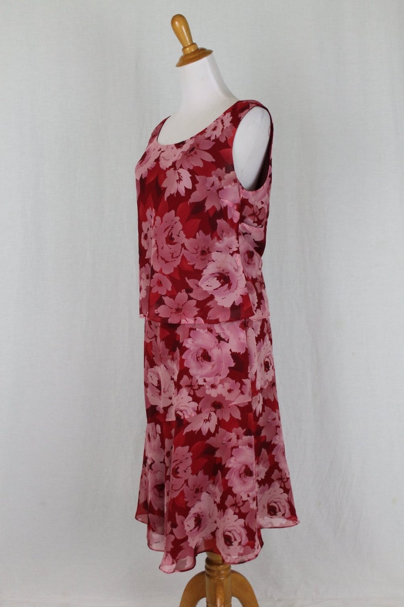 May include: A red and pink floral print sleeveless dress with a fitted bodice and a flowing skirt.