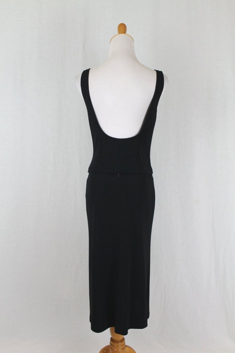 K&ouml;nnte beinhalten: Ein schwarzes, &auml;rmelloses Kleid mit tiefem R&uuml;cken und einem figurbetonten Rock.
