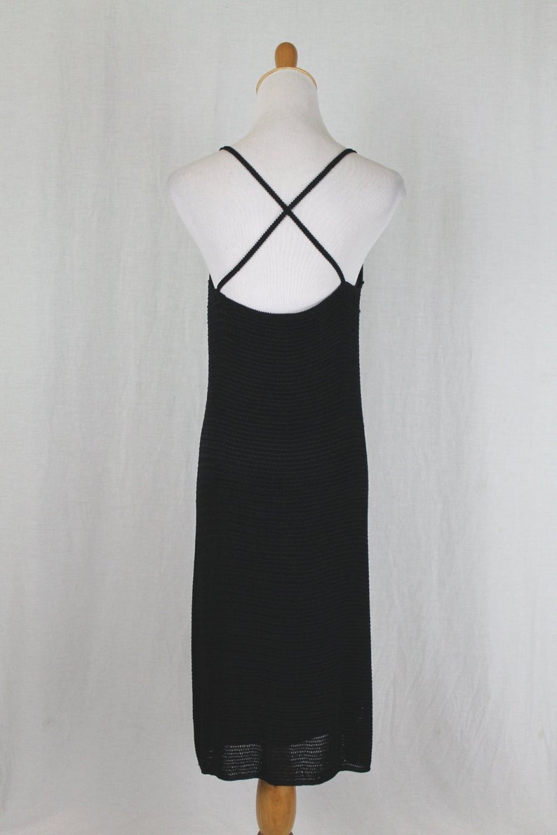 May include: Black midi dress with a criss-cross strap back.