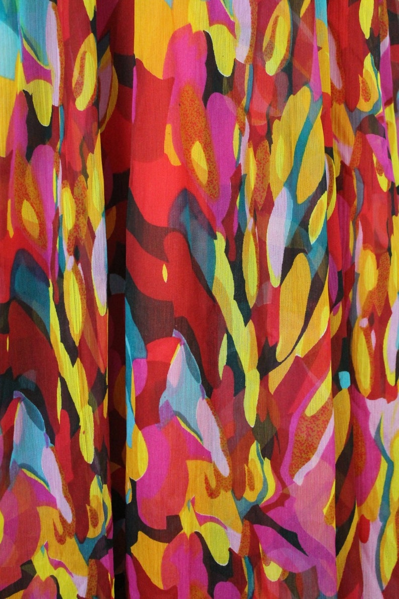 May include: Abstract floral print fabric in shades of red, yellow, pink, and blue. The fabric has a sheer, gauzy texture.