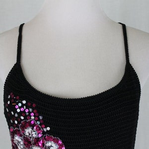 May include: A black crocheted tank top with pink and silver sequins in a floral design.