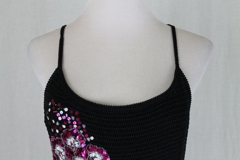 May include: A black crocheted tank top with pink and silver sequins in a floral design.