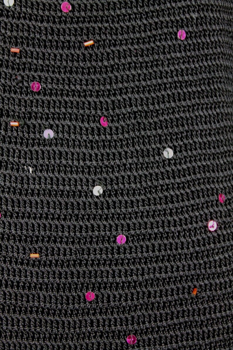 May include: Black fabric with a textured pattern and scattered sequins in pink, white, and orange.