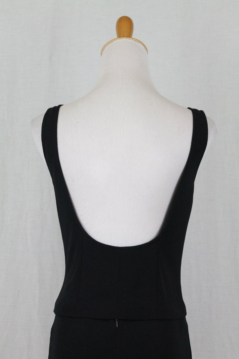 K&ouml;nnte beinhalten: Ein schwarzes, &auml;rmelloses Kleid mit tiefem R&uuml;cken und einem figurbetonten Oberteil.