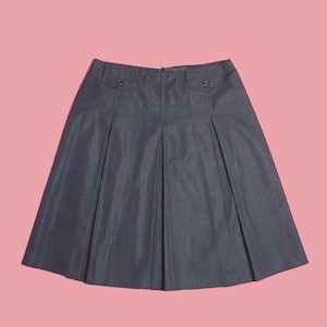 May include: A dark gray pleated skirt with two buttoned pockets on the front.