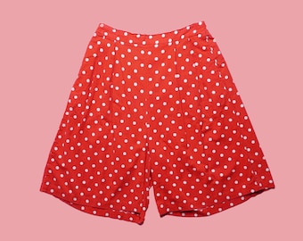 May include: Red and white polka dot shorts. The shorts have a high waist and are made of a lightweight fabric.
