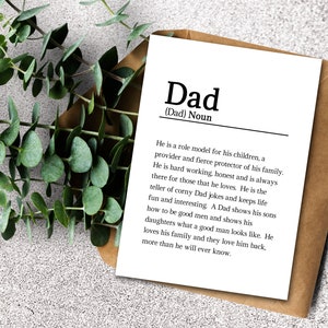 May include: A white card with black text defining the word "Dad" as a noun. The text describes a dad as a role model, provider, protector, hard worker, honest, and always there for those he loves. It also mentions that dads tell corny jokes, keep life fun and interesting, show their sons how to be good men, and show their daughters what a good man looks like. The text concludes by saying that dads love their family and their family loves them back, more than they will ever know.