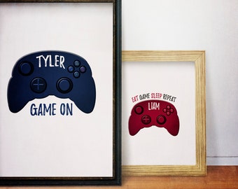 May include: Two framed prints with a video game controller design. The larger print is blue and says "Tyler Game On". The smaller print is red and says "Eat Game Sleep Repeat Liam".