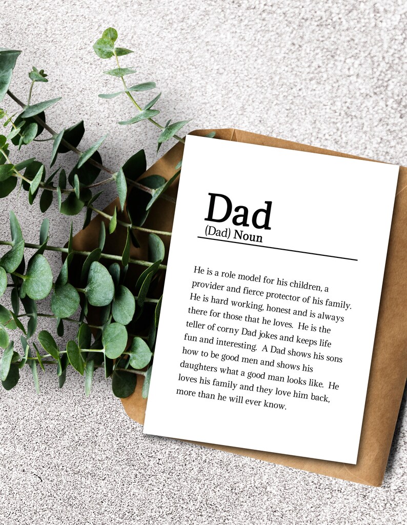 May include: A white card with black text defining the word "Dad" as a noun. The text describes a dad as a role model, provider, protector, hard worker, honest, and always there for those he loves. It also mentions that dads tell corny jokes, keep life fun and interesting, show their sons how to be good men, and show their daughters what a good man looks like. The text concludes by saying that dads love their family and their family loves them back, more than they will ever know.
