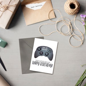 May include: A white card with a gray video game controller graphic and the text "Level 13 Unlocked" and "You Leveled Up! Happy Birthday!"