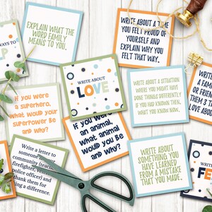May include: A set of colorful cards with prompts for writing exercises. The cards feature different colors and patterns, including blue, green, orange, and white. The text on the cards includes phrases like "Write about ways to help", "Write about love", and "Write about a time you felt proud of yourself".
