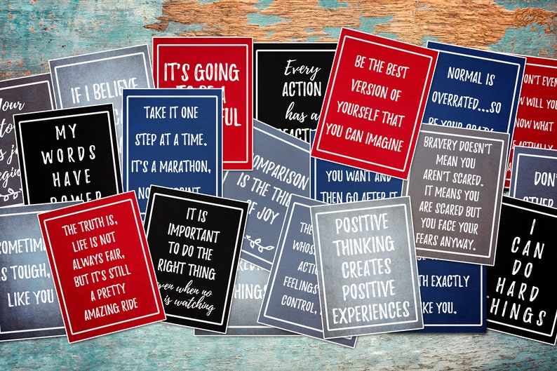 May include: A collection of motivational quote cards with various inspirational messages. The cards are printed on a textured paper with a chalkboard-like appearance. The cards are in red, blue, and gray colors with white text.