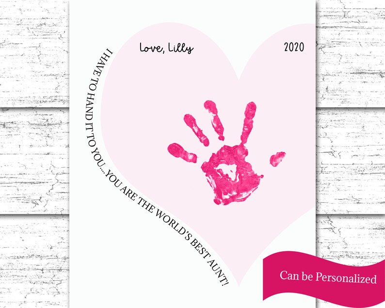 K&ouml;nnte beinhalten: Eine rosa herzf&ouml;rmige Karte mit einem rosa Handabdruck in der Mitte. Der Text "Love, Lilly" befindet sich oben auf der Karte. Der Text "I HAVE TO HAND IT TO YOU... YOU ARE THE WORLD'S BEST AUNT!" ist in einem Kreis um den Handabdruck geschrieben. Das Jahr "2020" befindet sich oben rechts auf der Karte. Der Text "Can be Personalized" befindet sich unten auf der Karte.
