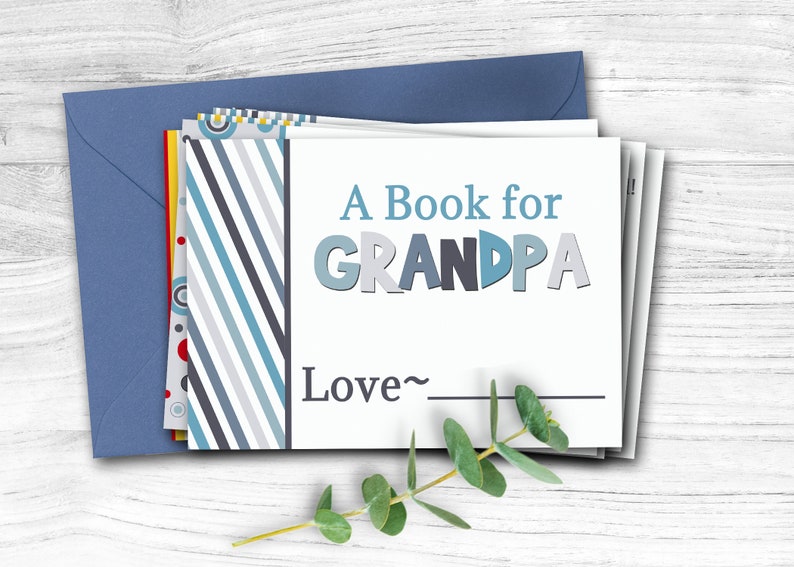 May include: A white card with blue and gray stripes on the left side. The card says "A Book for GRANDPA" in blue, gray, and white letters. Below the text, it says "Love~" with a line for a signature.