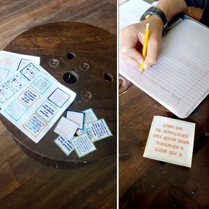 May include: A set of colorful cards with questions on them, such as "If you were a superhero, what would your superpower be and why?" The cards are on a wooden table. A person is writing in a notebook.