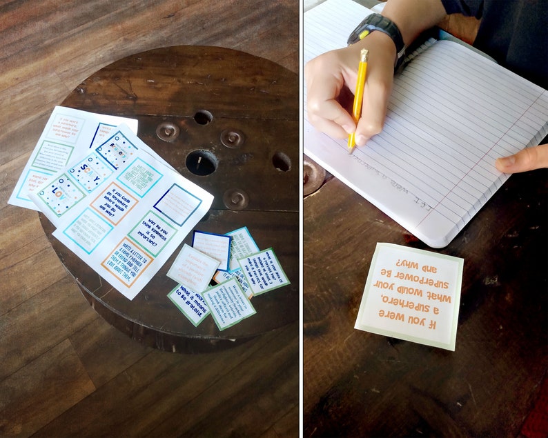 May include: A set of colorful cards with questions on them, such as "If you were a superhero, what would your superpower be and why?" The cards are on a wooden table. A person is writing in a notebook.