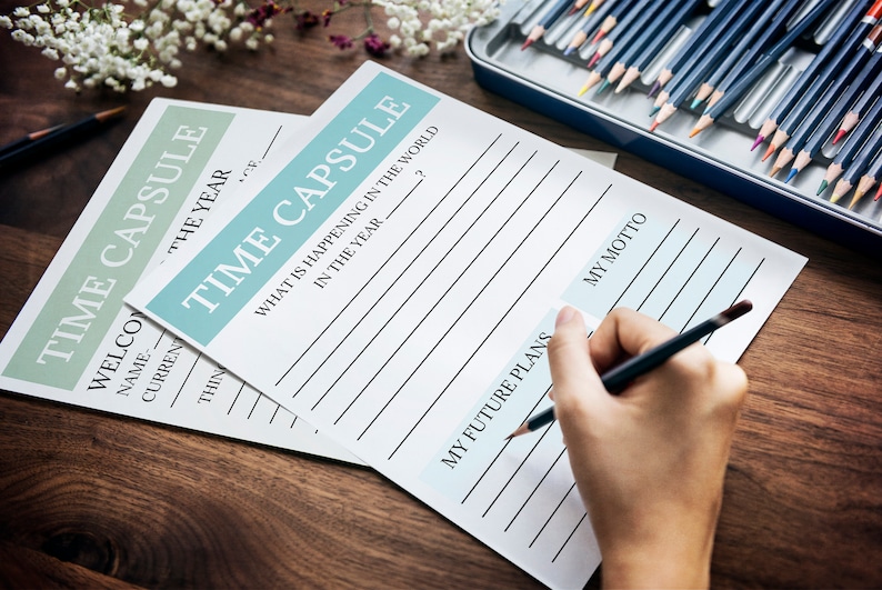A person is seen filling out the printable time capsule sheets.