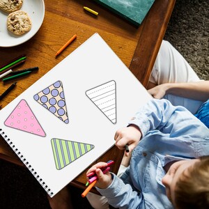 A child is seen sitting at a table with crayons in his hands, coloring in the Printable Easter Banner.