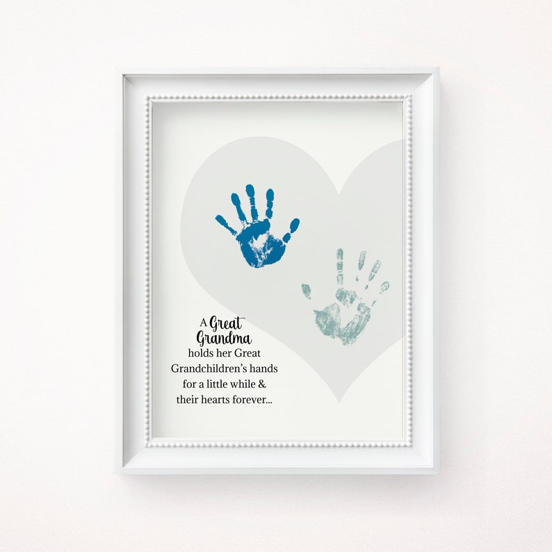 May include: A white framed print with a gray heart shape and two blue handprints. The text reads "A Great Grandma holds her Great Grandchildren's hands for a little while & their hearts forever..."