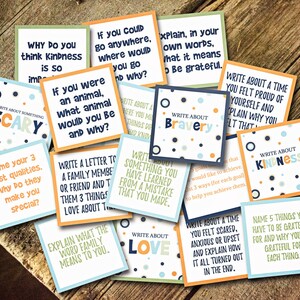 May include: A set of colorful cards with prompts for writing exercises. The cards feature various themes such as bravery, kindness, love, and gratitude. Each card has a different design with polka dots and a light blue, orange, or green background.