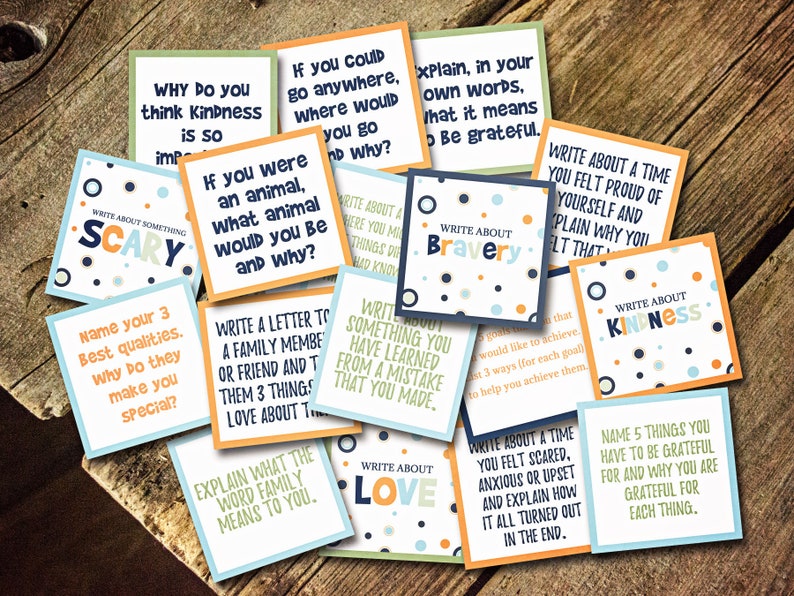 May include: A set of colorful cards with prompts for writing exercises. The cards feature various themes such as bravery, kindness, love, and gratitude. Each card has a different design with polka dots and a light blue, orange, or green background.