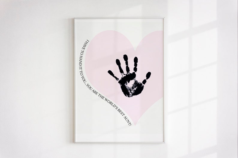 K&ouml;nnte beinhalten: Ein rosa Herz mit einem schwarzen Handabdruck in der Mitte. Der Text um das Herz herum lautet: "Ich muss es dir sagen - du bist die beste Tante der Welt!"