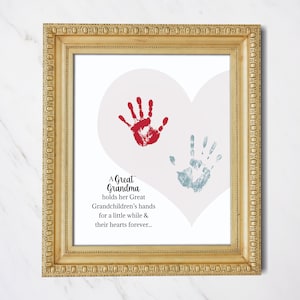 May include: A framed print with a heart shape and two handprints, one red and one blue. The text reads "A Great Grandma holds her Great Grandchildren's hands for a little while & their hearts forever..."